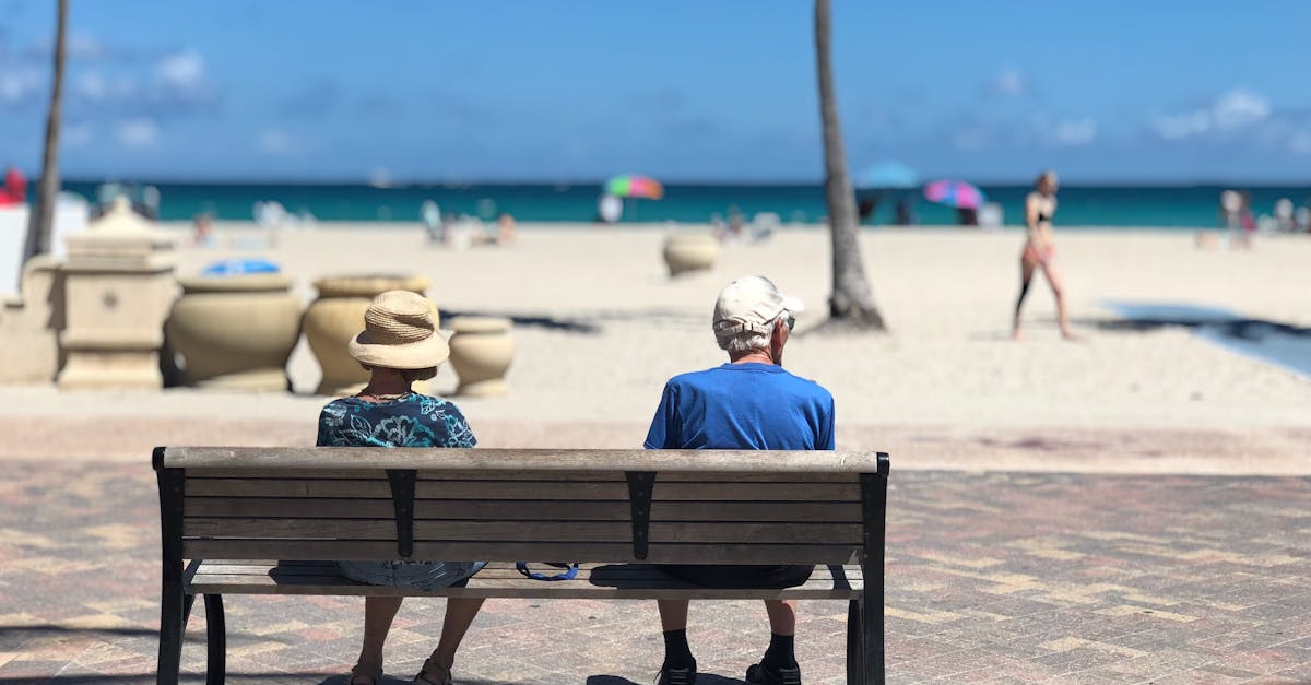 Senior couple sitting on a bench enjoying a sunny day at Hollywood Beach, Florida.